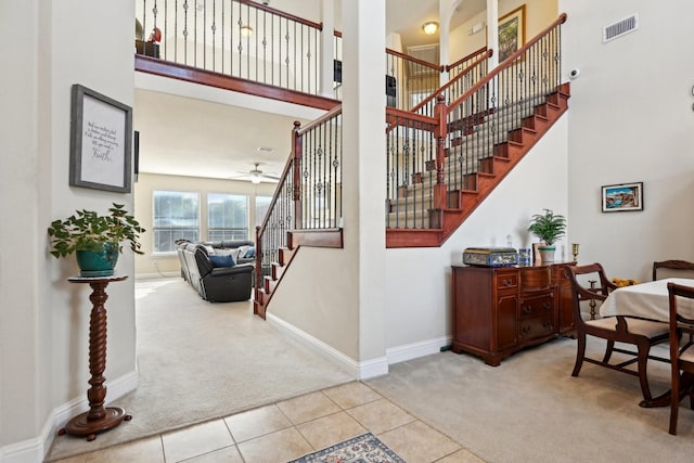 stairway featuring ceiling fan and carpet floors