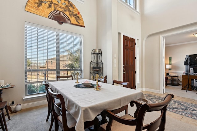 tiled dining area featuring a high ceiling and a wealth of natural light