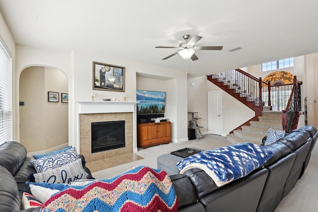 living room featuring ceiling fan, a fireplace, and light colored carpet