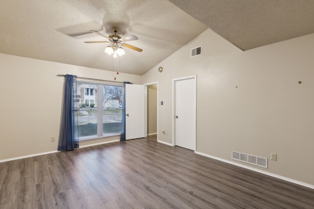 empty room featuring a textured ceiling, ceiling fan, dark hardwood / wood-style floors, and vaulted ceiling