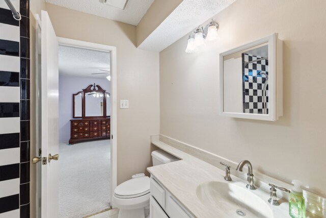 bathroom with vanity, a textured ceiling, toilet, and ceiling fan