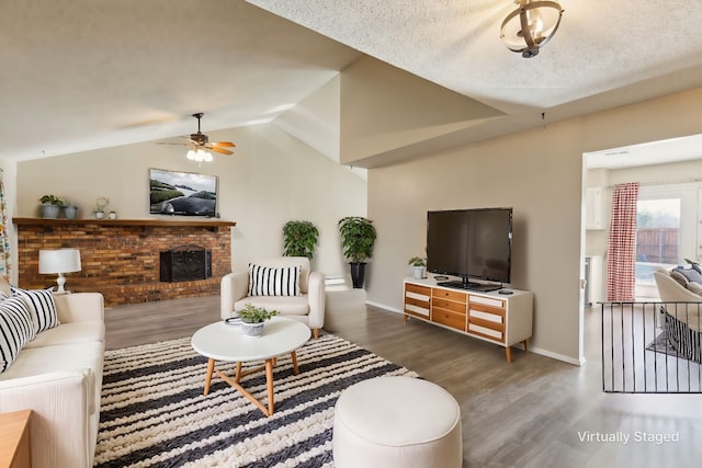 living room with dark hardwood / wood-style flooring, a brick fireplace, ceiling fan, and lofted ceiling