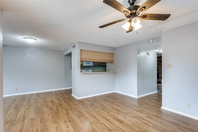 unfurnished living room with a textured ceiling, light hardwood / wood-style flooring, and ceiling fan