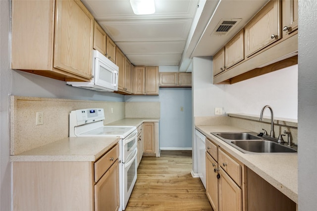 kitchen with light brown cabinetry, sink, white appliances, and light hardwood / wood-style flooring