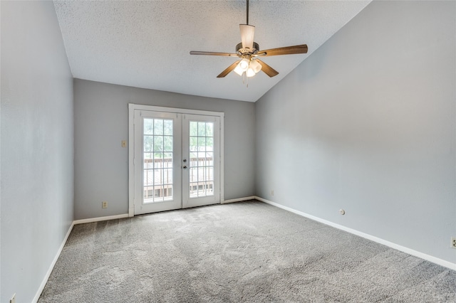 spare room featuring french doors, lofted ceiling, a textured ceiling, carpet floors, and ceiling fan