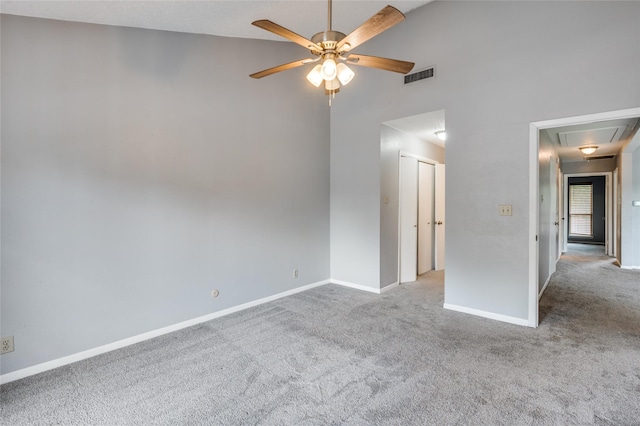 empty room featuring a towering ceiling, light colored carpet, and ceiling fan