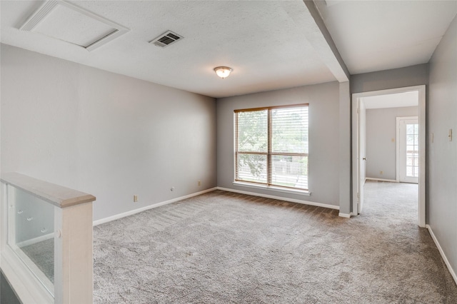 empty room with plenty of natural light, carpet flooring, and a textured ceiling