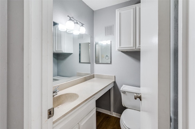 bathroom featuring vanity, hardwood / wood-style floors, and toilet