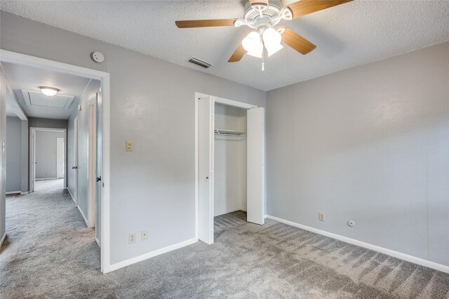 unfurnished bedroom with ceiling fan, light colored carpet, a closet, and a textured ceiling