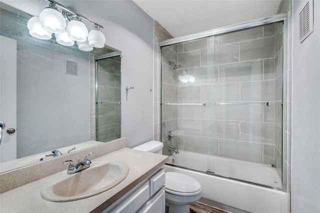 full bathroom with vanity, combined bath / shower with glass door, and toilet