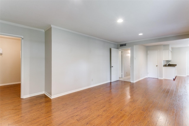 empty room featuring hardwood / wood-style floors and ornamental molding