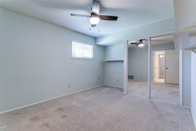 unfurnished bedroom featuring ceiling fan, light colored carpet, and a closet