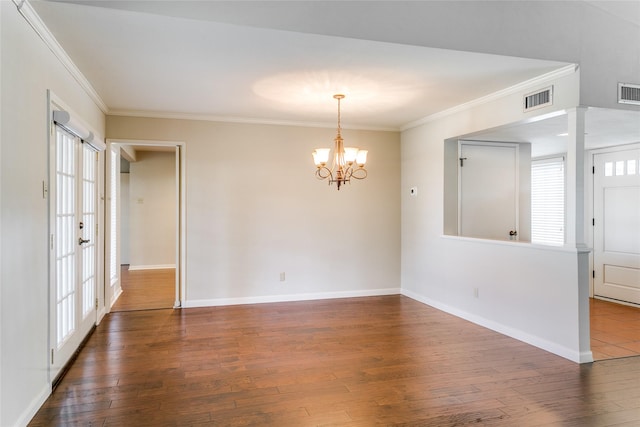 unfurnished room featuring dark hardwood / wood-style floors, an inviting chandelier, and crown molding