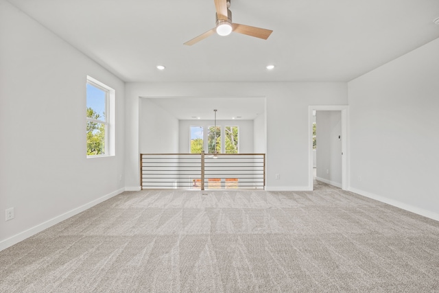 spare room with ceiling fan and light colored carpet