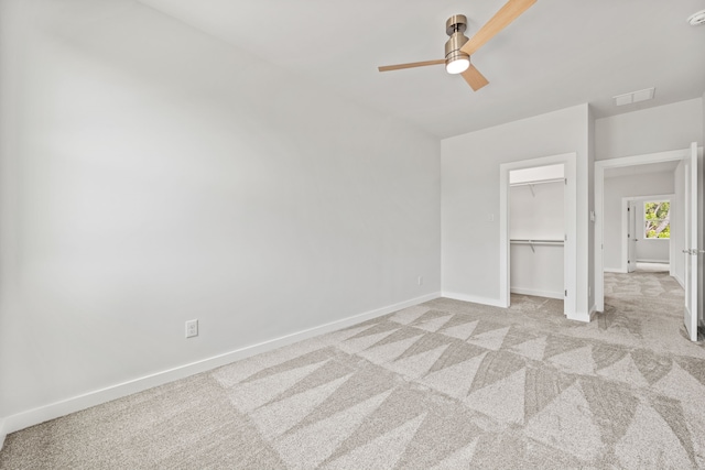 unfurnished bedroom featuring ceiling fan, a closet, and light colored carpet