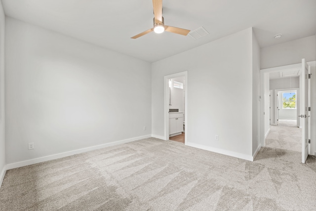 unfurnished bedroom with ceiling fan, light carpet, and connected bathroom