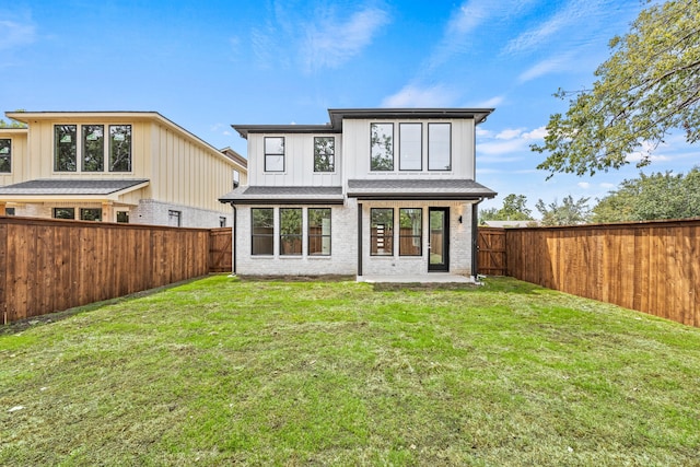 back of house featuring a lawn and a patio area