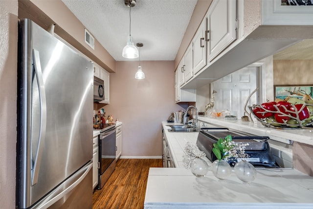 kitchen with white cabinets, sink, hanging light fixtures, a textured ceiling, and appliances with stainless steel finishes