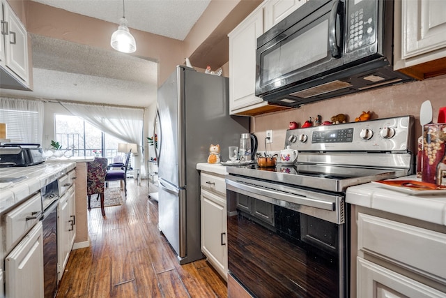 kitchen featuring appliances with stainless steel finishes, white cabinetry, and pendant lighting