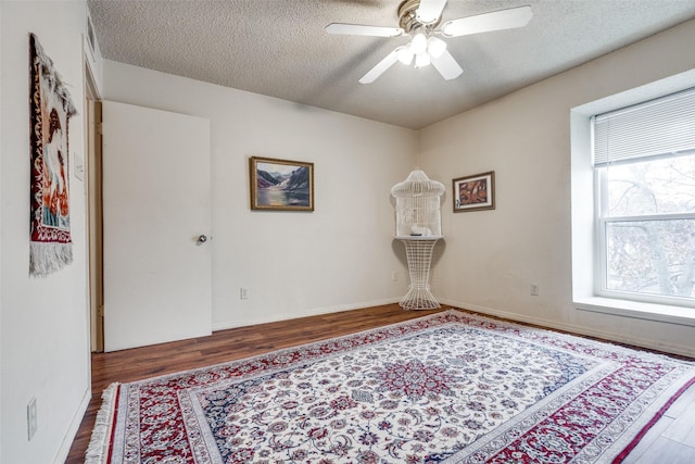 spare room featuring hardwood / wood-style floors, ceiling fan, and a textured ceiling