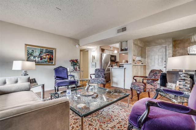 living room with wood-type flooring and a textured ceiling