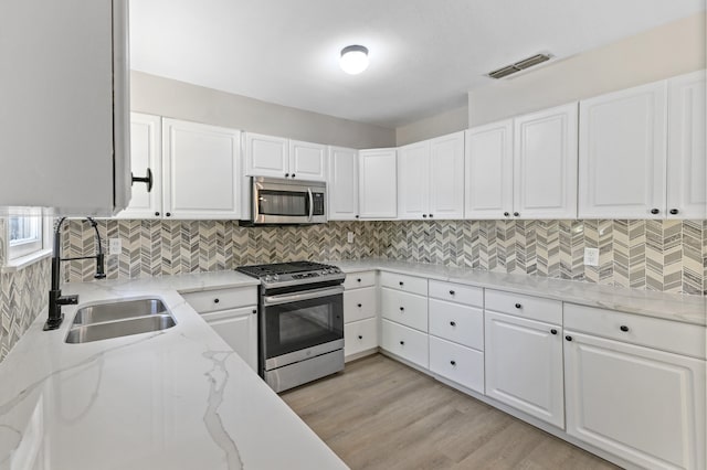 kitchen featuring white cabinetry, sink, and appliances with stainless steel finishes