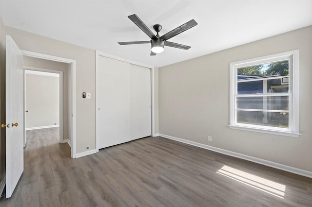 unfurnished bedroom with ceiling fan, a closet, and hardwood / wood-style flooring