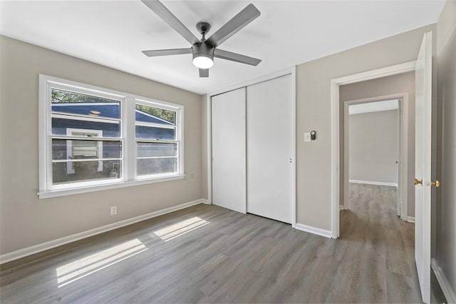 unfurnished bedroom featuring ceiling fan, a closet, and light hardwood / wood-style floors