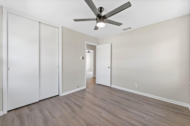 unfurnished bedroom with ceiling fan, a closet, and light hardwood / wood-style floors