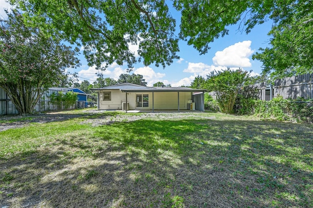 rear view of house featuring a patio area and a yard