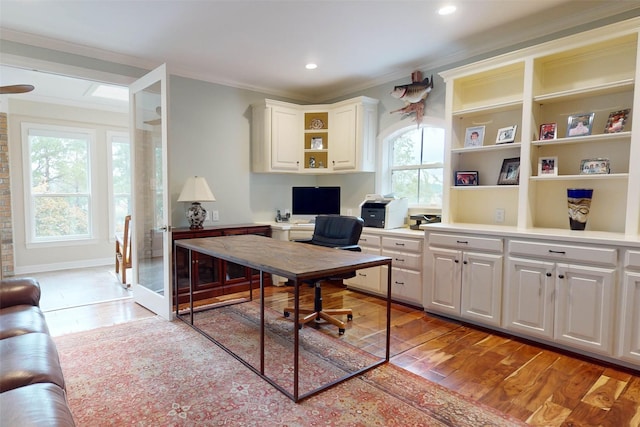 office with light hardwood / wood-style floors and crown molding