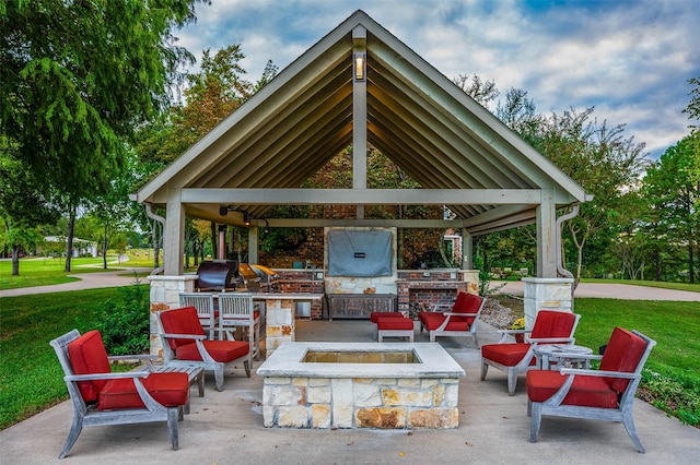 view of patio / terrace with a gazebo, a fire pit, grilling area, and exterior kitchen