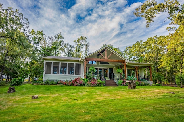 back of property featuring a porch, a yard, and a sunroom