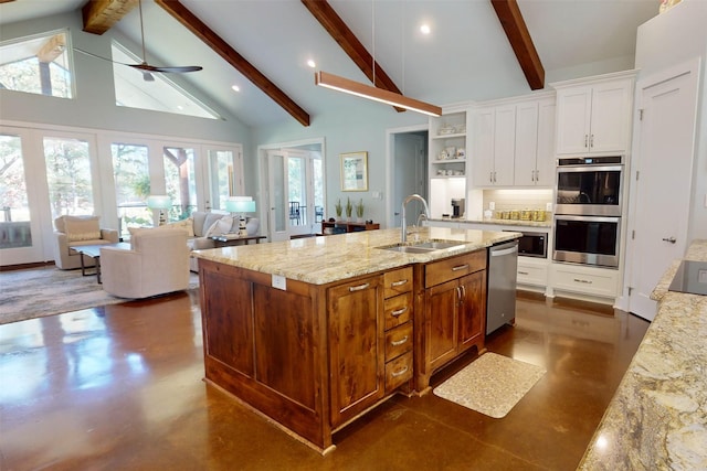 kitchen with french doors, stainless steel appliances, ceiling fan, a kitchen island with sink, and sink