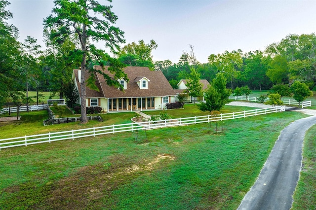 back of house featuring a rural view and a lawn