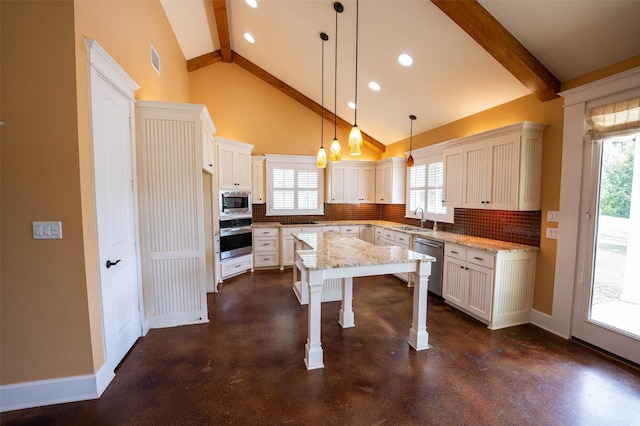 kitchen with sink, stainless steel appliances, tasteful backsplash, decorative light fixtures, and a kitchen island