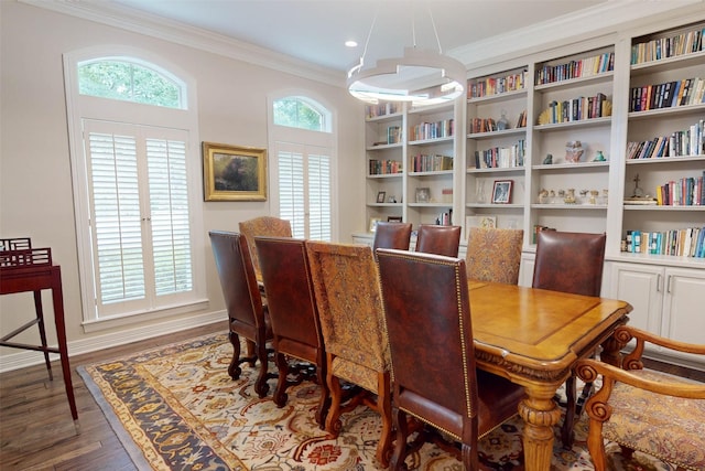 dining area with crown molding and dark wood-type flooring