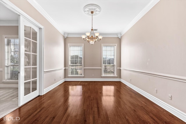 unfurnished dining area with dark wood-type flooring, ornamental molding, and a notable chandelier