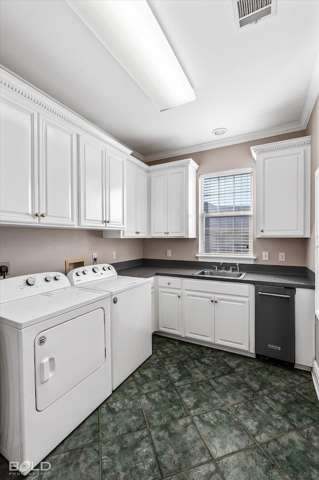 laundry area featuring cabinets, ornamental molding, washer and clothes dryer, and sink