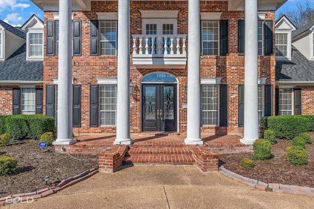 view of exterior entry featuring french doors and a balcony