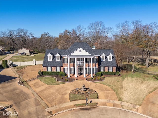 greek revival house with a balcony and a front lawn