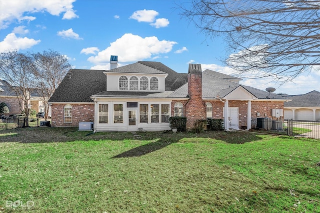 rear view of house with a sunroom and a lawn