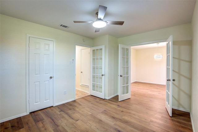 unfurnished bedroom with french doors, ceiling fan, and light hardwood / wood-style flooring