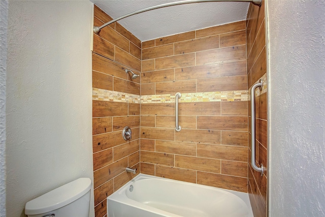 bathroom featuring tiled shower / bath, toilet, a textured ceiling, and wood walls