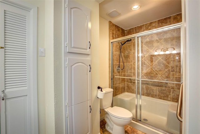 bathroom featuring toilet and an enclosed shower