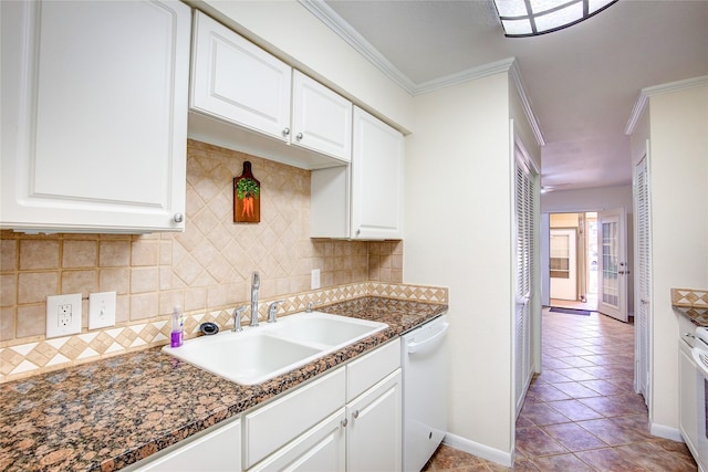 kitchen with sink, white dishwasher, ornamental molding, white cabinets, and dark stone counters