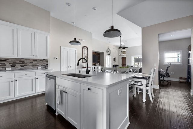 kitchen with pendant lighting, dishwasher, an island with sink, sink, and white cabinets