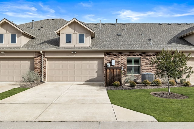 view of front facade featuring cooling unit, a garage, and a front lawn