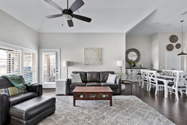 living room featuring dark wood-type flooring and ceiling fan