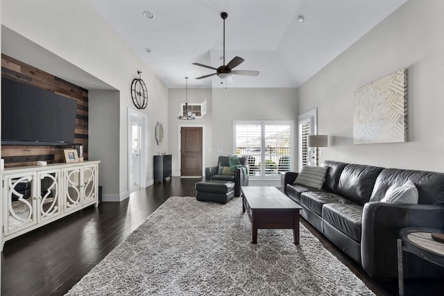 living room featuring a towering ceiling, dark wood-type flooring, and ceiling fan